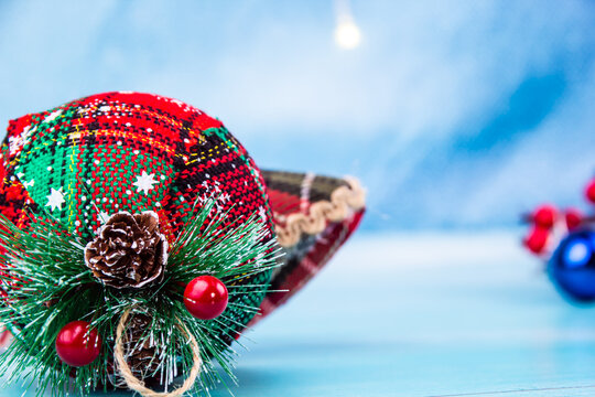 Close-up of a red and green Christmas ornament with small cones on it