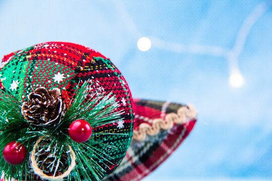 Close-up of a red and green Christmas ornament with small cones on it