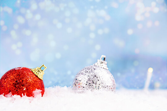 Close-up of bright red and silver Christmas decorations buried in snow