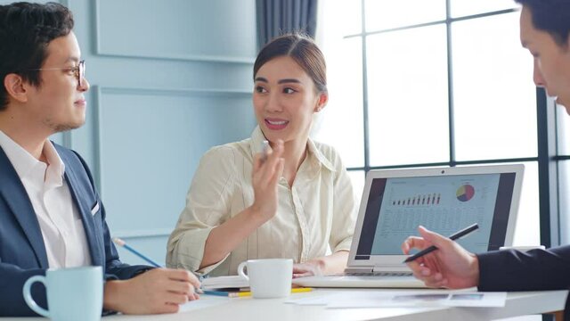 Group of Asian business people working, meeting about business plan and present and explain financial chart from laptop computer.