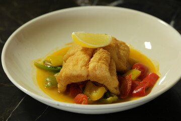 Fish with vegetables in plate. Tasty dish at restaurant.