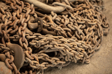 Old rusted steel chain background. Abstract of Thick Rusty Chain Background Image. Bundle of rusty naval chains laying on the pier.