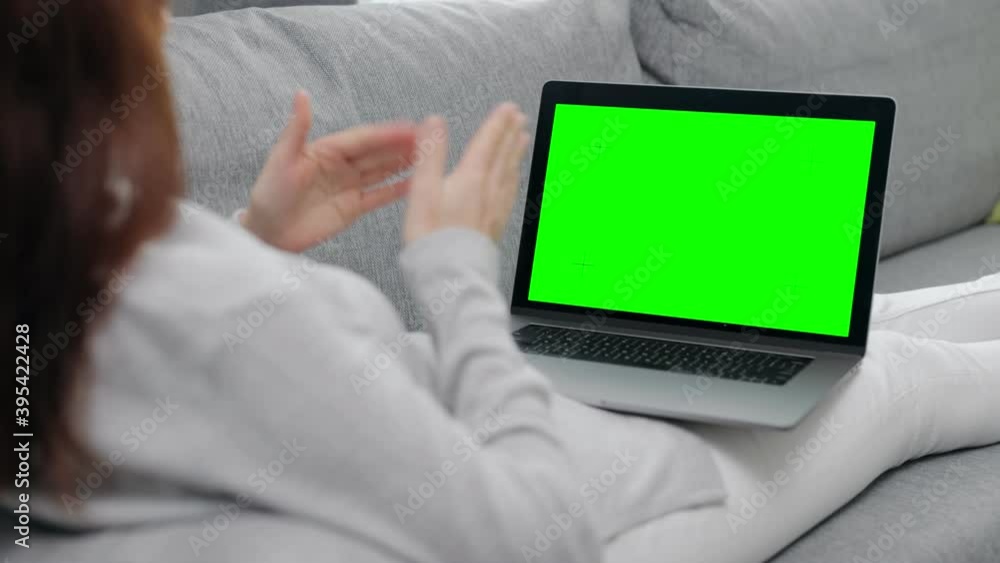 Poster Back view of woman relaxing on comfy sofa and having video chat on portable computer. Close up of chroma key screen of laptop. Concept of technology.