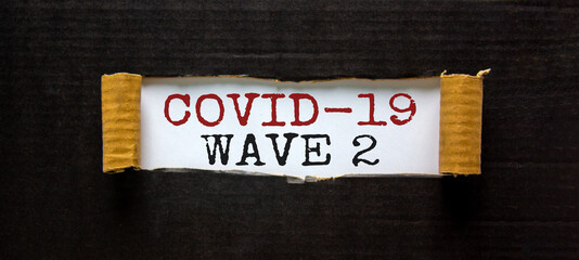 Covid-19 wave 2. The words 'covid-19 wave 2' appearing behind torn black paper. Beautiful background. Covid-19 pandemic wave 2 concept.
