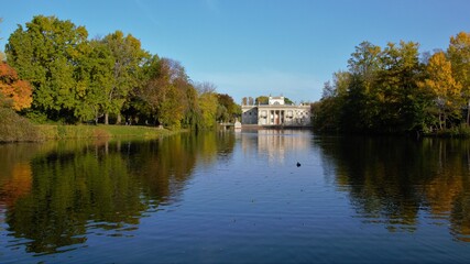 Obraz premium Autumn time in Warsaw's Royal Baths Park (in Polish: Lazienki Krolewskie). Palace on the Water and pond with reflections in the water. Warsaw, Poland