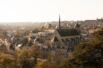 Fototapeta na wymiar Cityscape of Poitiers, France. View on the roof. There is a church. Light coming from the right. Photographed in autumn, on a sunny day.