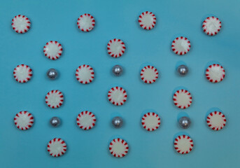 Round Peppermint candy sweet food pattern on blue paper background for winter, Christmas, New Year's, December, flat lay 