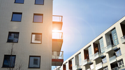Modern apartment buildings on a sunny day with a blue sky. Facade of a modern apartment building. Glass surface with sunlight.
