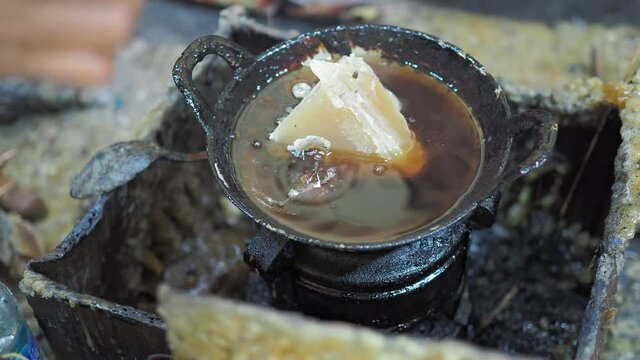 Adding paraffin wax or malam on the pan stove as preparation batik painting process