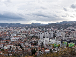 Fototapeta na wymiar Cityscape of Clermont-Ferrand, a city and commune of France, in the Auvergne-Rhône-Alpes region. Cloudy sky.