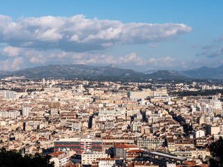 Cityscape in Marseille, a french city located in the south. Cloudy sky. Mountain in the background. Photographed in the evening.