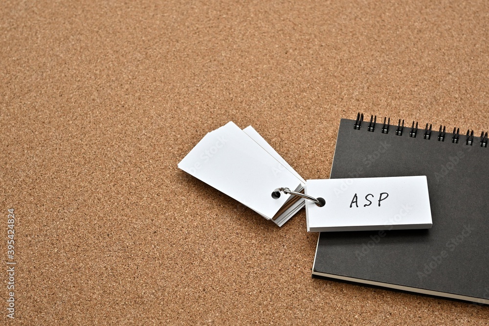 Poster on top of the notebook on the cork board is a wordbook with the word asp written on it. it means app