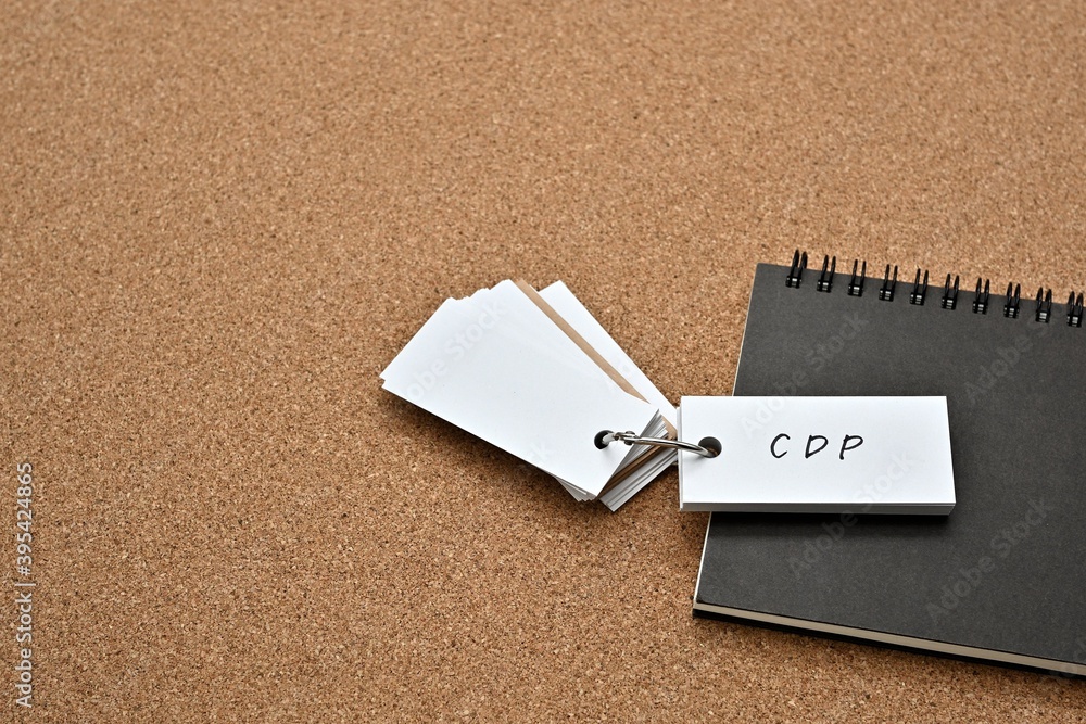 Poster on top of the notebook on the cork board is a wordbook with the word cdp written on it. it means cus