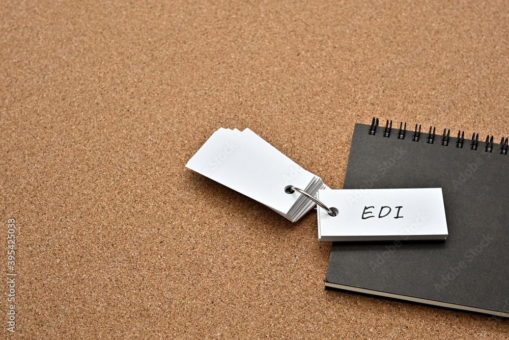 Aufkleber on top of the notebook on the cork board is a wordbook with the word edi written on it. it means ele