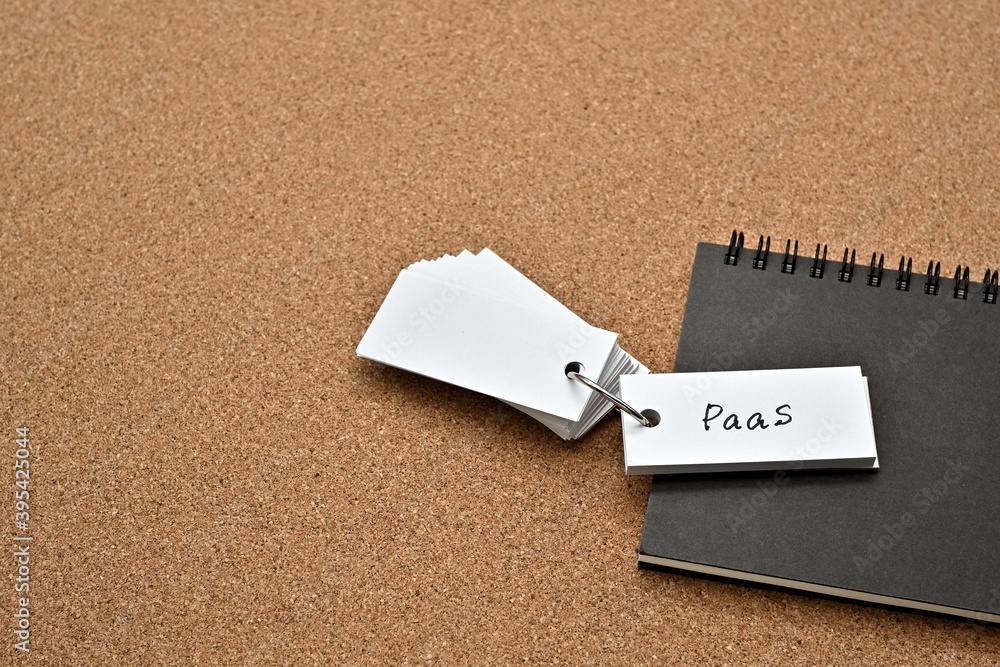 Poster on top of the notebook on the cork board is a wordbook with the word paas written on it. it means pl
