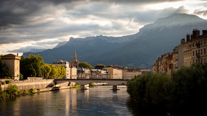 Obraz premium View on the Isère river in Grenoble, France. Photographed in the evening. Grenoble is the prefecture and largest city of the Isère department in the Auvergne-Rhône-Alpes region of Southeastern France.