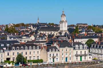 Fototapeta na wymiar Cityscape of Angers. View on the quays and a church. Blue sky, sunny day. Angers is a city located in western France, in the maine-et-loire department. Summer.