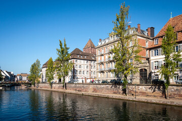 Fototapeta na wymiar View on the quays of the island of Strasbourg. The city is located in the east of France, in the region of Alsace. Photographed on a sunny day. Blue sky.