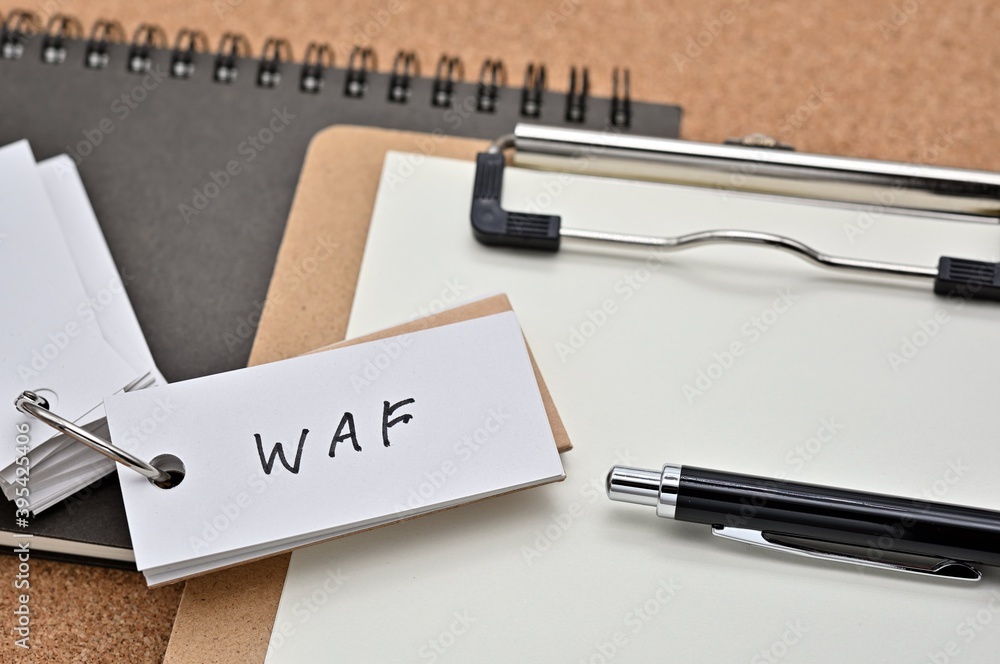 Poster on top of the notebook and clipboard is a wordbook and pen with the word waf written on it. it means