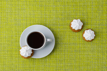 Cup of coffee and grapes on a green tablecloth