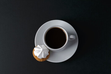 White cup of coffee and cake on black table