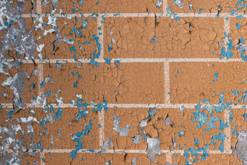 Peeling paint on the wall. Old concrete wall with cracked flaking paint. Weathered rough painted surface with patterns of cracks and peeling. Grunge texture for background and design. High resolution.