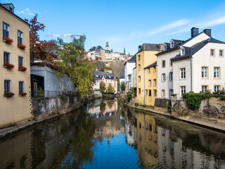 Fototapeta na wymiar Canal in the old center of Luxembourg city in Europe. Reflection on the water. Sunny day, blue sky, autumn.