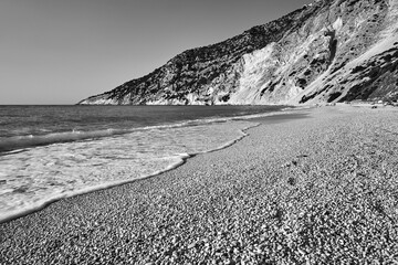 People resting on the rocky Mitros beach on the island of Kefalonia