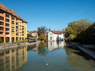 View on the canals of the city of Annecy. The colorful buildings are reflected in the water. Photographed during autumn.