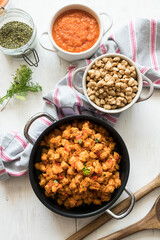 Healthy vegan scene composed of casseroles of bolognese soya meat, raw chunks of soy and tomato sauce.