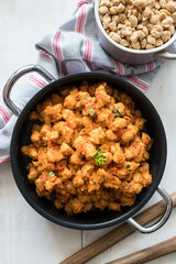 A black casserole full of healthy bolognese soya meat.