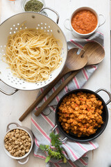 Vegan food scene composed of soya meat, raw soya chunks, tomato sauce and bolognese soya meat.