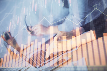 Multi exposure of woman hands typing on computer and financial chart hologram drawing. Stock market...