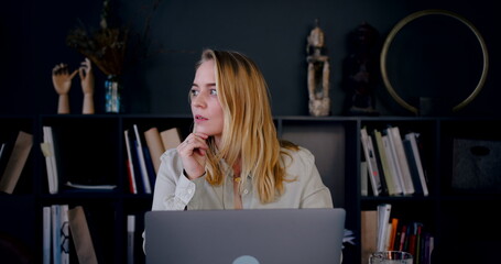 Portrait of beautiful happy young blonde Caucasian creative writer woman using laptop, thinking of ideas slow motion.