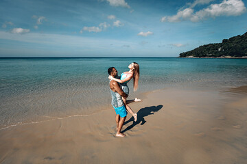 Fototapeta na wymiar A romantic couple on the beach in a swimsuit, beautiful sexy young people. Phuket. Thailand.