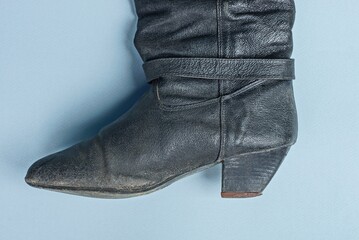 part of an old black female leather boot on a gray table