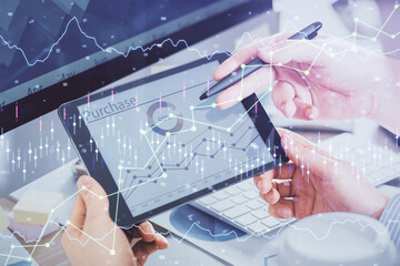 Double exposure of man's hands holding and using a phone and financial chart drawing. Market analysis concept.