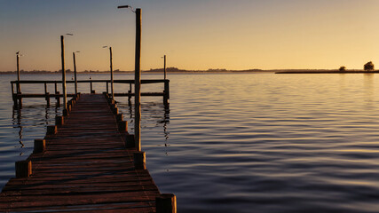  Sunset at Lobos lake, Buenos Aires. Taken from the shore looking to an old large wooden pier and the lake                                            