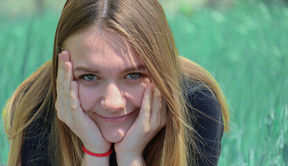 Close-up portrait of a young beautiful girl of fifteen years on the background of nature.