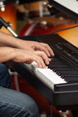 Fototapeta premium Hands of a musician or pianist playing a piano keyboard during a musical performance in a square.