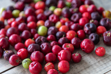 Acerola fruits (Malpighia emarginata) in natura on wooden background