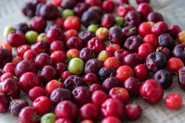 Acerola fruits (Malpighia emarginata) in natura on wooden background