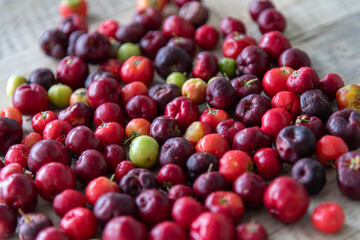 Acerola fruits (Malpighia emarginata) in natura on wooden background
