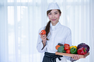Beautiful chef with beautiful vegetables. Female Chef preparing food, Many fresh vegetables for cooking.