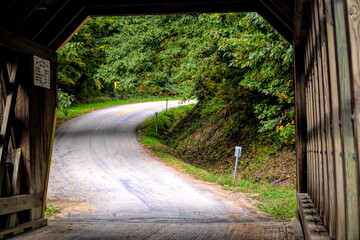 Covered bridge opening  to a view of a winding road in Ashtabula, Ohio close-up.