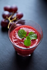 Fresh smoothie in a glass. Dark background. Close up.	