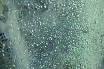 Frozen pattern. Melting ice on the window.