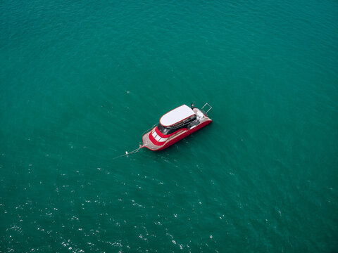 Aerial picture of an isolated yacht with red design in the sea