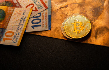 Bitcoin coins lying on a shiny copper plate with Swiss francs - banknotes of 10, 20, 100 francs.