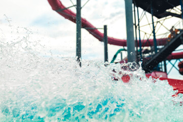 Water park adventure aqua park with cool people having fun on the water slide with friends and familiy in the aqua fun park glides playing happy in the sunlight and water splashes blue sky background